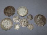 several different types of silver coins on a blue surface