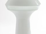 a white vase that is sitting on a white surface