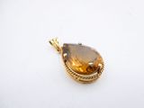 a close up of a pendant on a white surface