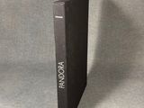a black book sitting on top of a table next to a gray wall