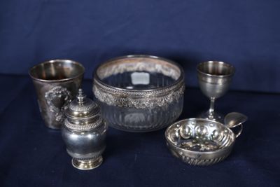 trois tasses en argent et un bol posés sur une table