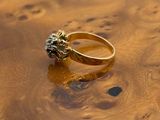 an image of a gold ring sitting on top of a wooden table