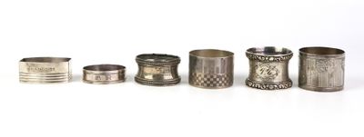 six serviettes et tasses en argent sont alignées sur une surface blanche