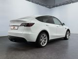 the rear end of a white tesla suv parked in a garage