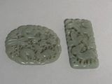 two pieces of green jade on a white surface