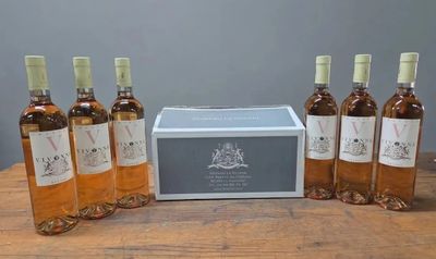 six bouteilles de vin posées sur une table en bois, à côté d'une boîte