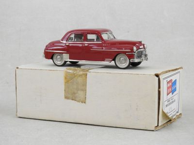 une petite voiture rouge posée sur une boîte