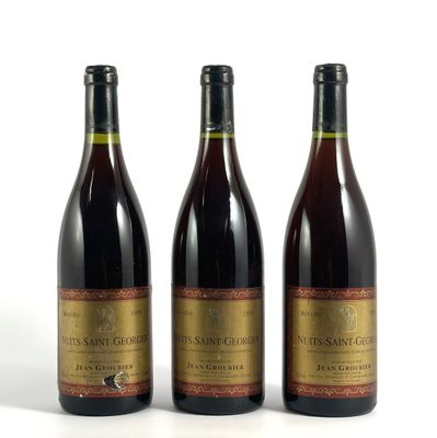 trois bouteilles de vin posées les unes à côté des autres sur une surface blanche