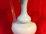 a white vase sitting on a red table cloth