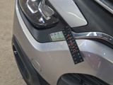a close up of a car ' s headlight with a ruler attached to it