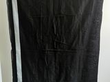 une couverture noire et blanche suspendue à un portant dans une pièce