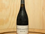 une bouteille de vin posée sur un tonneau en bois