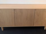 the sideboard is made out of wood and has three doors
