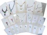 many different types of jewelry displayed on a white surface