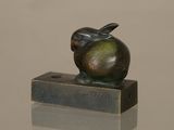 a bronze sculpture of an apple sitting on top of a block