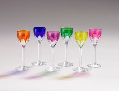 plusieurs verres à vin de couleurs différentes sont alignés
