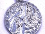 an image of a silver medal with the image of the virgin mary and child jesus