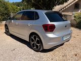 a silver volkswagen polo parked in front of a house