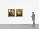 a man standing in front of two paintings on the wall