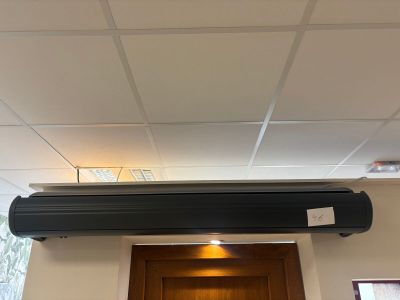a black air conditioner hanging from the ceiling in a room