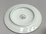 a white plate with a black design on it next to a white plate with a black design on it