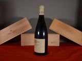 a bottle of wine sitting on a table next to three wooden boxes