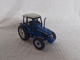 a toy tractor that is sitting on a white surface