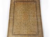 un tapis ancien à fond beige et bordure marron