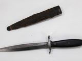 a knife and a piece of wood on a table
