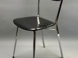 une chaise noire avec une structure en métal et une assise noire