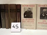 Plusieurs livres sont alignés sur une surface blanche, avec un petit nombre