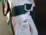 a white bag with a green strap and a white bag with a green strap