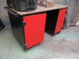 un bureau rouge et noir sur lequel se trouve une boîte noire