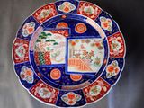 une assiette bleue ornée de motifs rouges et blancs
