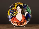 a plate with a painting of a woman in a red dress