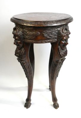 une vieille table en bois avec un plateau et des pieds sculptés