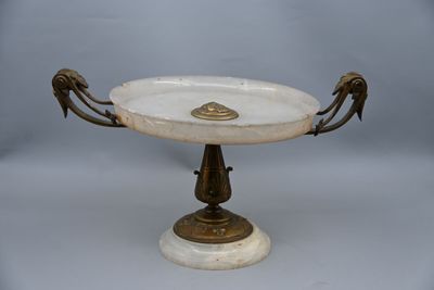 a white marble pedestal with a bird handle on it