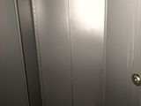 an open metal door in a room with a wooden floor