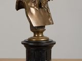 bronze bust of a woman on a pedestal on a wooden table