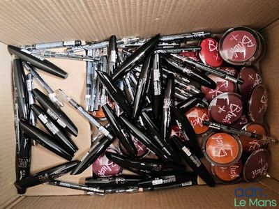 une boîte remplie de rouges à lèvres et de stylos