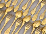 a lot of forks and spoons that are on the table