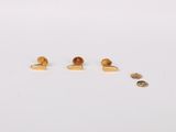 a pair of gold stud earrings sitting on top of a white surface