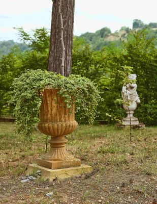 trois statues dans un jardin, avec un arbre en arrière-plan