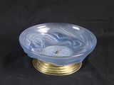 a blue glass bowl with a gold base on a black background