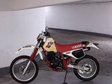 a red and white motorcycle parked in a parking garage