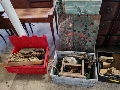 de nombreuses boîtes remplies de bric-à-brac posées par terre à côté d'une commode