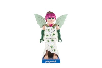 La figurine d'une fée aux cheveux roses et aux ailes vertes est posée sur un socle bleu.
