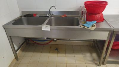 two sinks in the kitchen with a red bucket on the counter