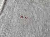 a white shirt with a small red embroidered on it