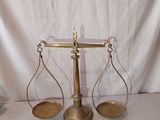 une vieille balance en laiton sur laquelle se trouvent deux plateaux vides